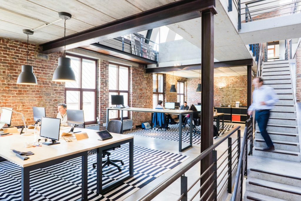 Modern kantoorinterieur met medewerkers die samenwerken, symboliserend een werkplek die past bij jouw ambities